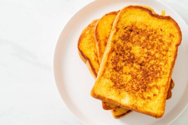 Kahvaltı için beyaz tabakta yumurtalı ekmek.