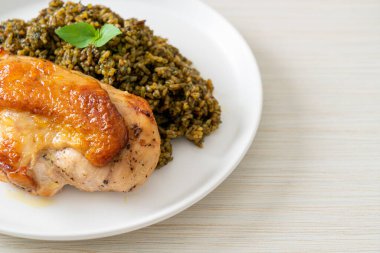 Kızarmış pesto pilavı ve beyaz tabakta kızarmış tavuk.