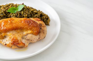 Kızarmış pesto pilavı ve beyaz tabakta kızarmış tavuk.