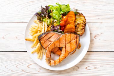 Çift ızgara somon bifteği, sebze ve patates kızartması.