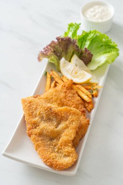 balık ve patates kızartması - kızarmış balık fileto patates cipsi ve limonlu beyaz tabak