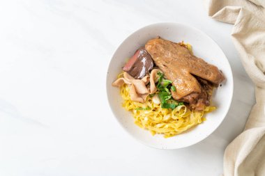 Yumurtalı erişte, kurutulmuş ördekle servis edilir. Asya usulü.