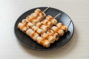 Izgara tüp şeklinde balık ezmeli kek ya da tabakta mürekkep balığı şişi.