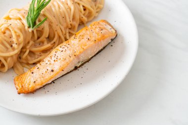 Kızarmış somon filetosu ve spagetti kremalı domates sosu.