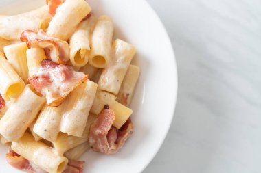 Beyaz soslu ve pastırmalı ev yapımı spagetti rigatoni makarna. İtalyan usulü.