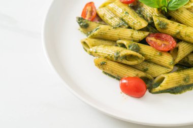 Pesto soslu ve domatesli makarna. Vejetaryen ve vejetaryen yemek tarzı.
