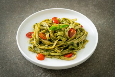 pesto soslu ve domatesli makarna vejetaryen ve vejetaryen yemek tarzı.