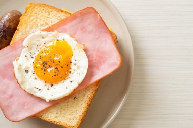 Ev yapımı kızarmış peynir üzerine jambon ve kahvaltıda domuz sosisli sahanda yumurta.