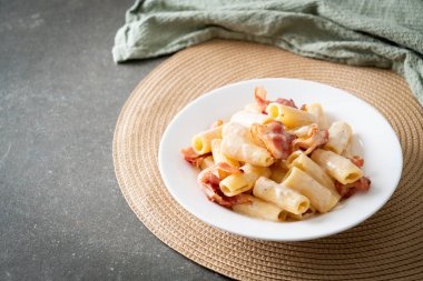 Beyaz soslu ve pastırmalı ev yapımı spagetti rigatoni makarna. İtalyan usulü.