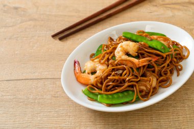 Kızarmış yakisoba eriştesi, yeşil bezelye ve karides, Asya usulü.
