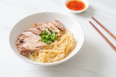 Beyaz kasede pişmiş ördekle kurutulmuş şehriye. Asya usulü.