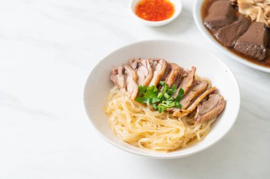 Beyaz kasede pişmiş ördekle kurutulmuş şehriye. Asya usulü.