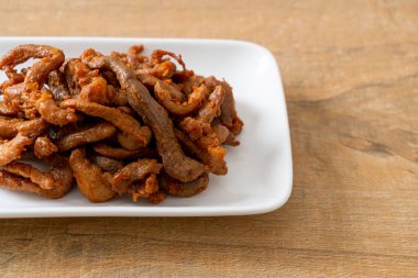 Beyaz tabakta kurutulmuş domuz eti, Asya yemeği tarzı.