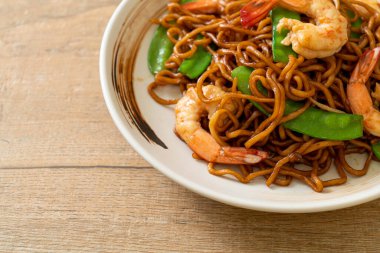 Kızarmış yakisoba eriştesi, yeşil bezelye ve karides, Asya usulü.