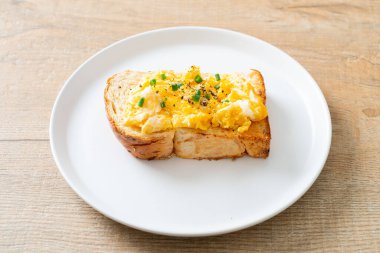 Ekmek tostu, çırpılmış yumurta ve beyaz tabak.