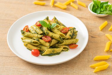 Pesto soslu ve domatesli makarna. Vejetaryen ve vejetaryen yemek tarzı.