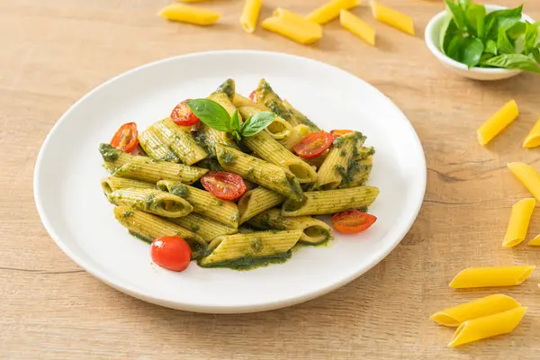 Pesto soslu ve domatesli makarna. Vejetaryen ve vejetaryen yemek tarzı.