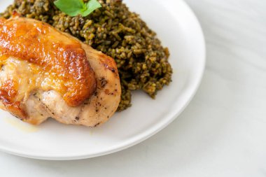 Kızarmış pesto pilavı ve beyaz tabakta kızarmış tavuk.
