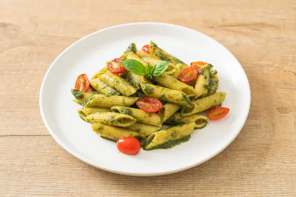 Pesto soslu ve domatesli makarna. Vejetaryen ve vejetaryen yemek tarzı.