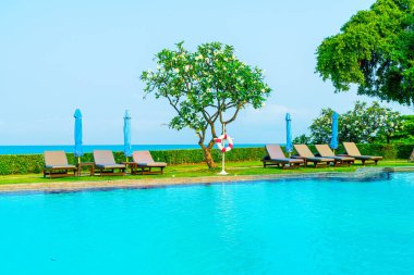 Havuz kenarındaki havuz, havuz, şemsiye, deniz manzaralı havuz tatilleri ve tatil konsepti.