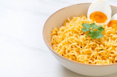 Hazır erişte kasesi ve tuzlu yumurta.