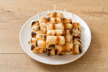 Izgara tüp şeklinde balık ezmeli kek ya da tabakta mürekkep balığı şişi.