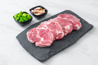 Taze domuz boyunlu ya da yakalı domuz eti ve terbiye edilecek malzemeler.