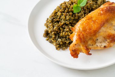 Kızarmış pesto pilavı ve beyaz tabakta kızarmış tavuk.