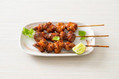 Izgara tavuk şişi. Tabakta baharat ve şifalı otlar var.