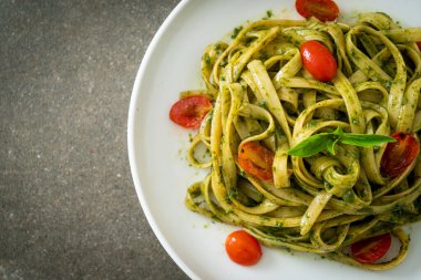 pesto soslu ve domatesli makarna vejetaryen ve vejetaryen yemek tarzı.