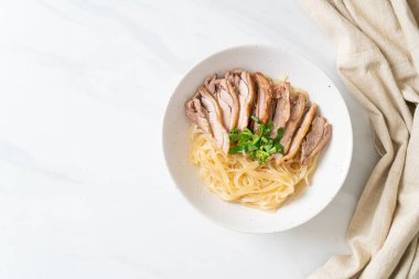 Beyaz kasede pişmiş ördekle kurutulmuş şehriye. Asya usulü.