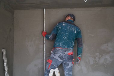 İnşaat için duvarlara sıva işçileri yapıştırılıyor.