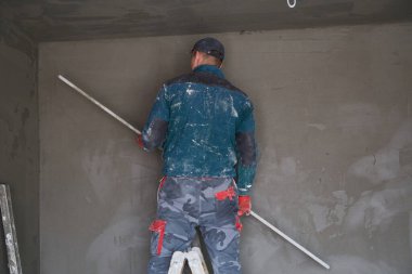 İnşaat için duvarlara sıva işçileri yapıştırılıyor.