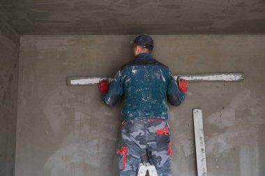 İnşaat için duvarlara sıva işçileri yapıştırılıyor.