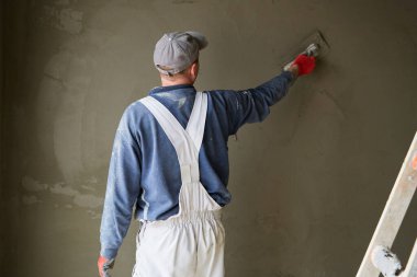 İnşaat için duvarlara sıva işçileri yapıştırılıyor.