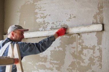 İnşaat için duvarlara sıva işçileri yapıştırılıyor.