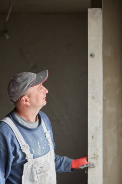 İnşaat için duvarlara sıva işçileri yapıştırılıyor.