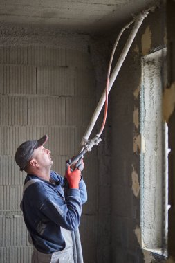 İnşaat için duvarların sıvanması. Pompalama ekipmanı kullanan bir malzeme katmanının uygulaması