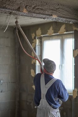 İnşaat için duvarların sıvanması. Pompalama ekipmanı kullanan bir malzeme katmanının uygulaması