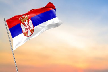 Güneşin doğuşuyla birlikte rüzgarda sallanan güzel Sırp bayrağı. Sırp bayrağı
