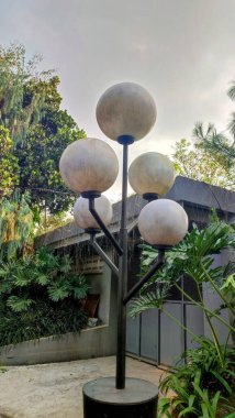 Evin önünde siyah direkli bir sokak lambası..