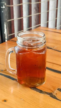 Tahta masadaki bir bardak taze buzlu çayı kapat..