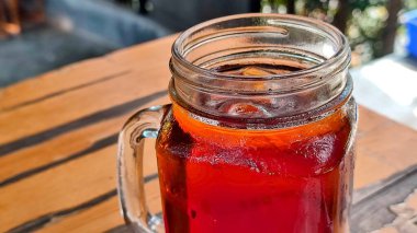 Tahta masadaki bir bardak taze buzlu çayı kapat..