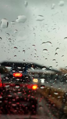 Otoyol üzerindeki trafik sıkışıklığında yağmur suyu arabanın camından aşağı akıyor..