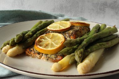 Lezzetli bitkisel kabuklu somon filetosu: Buharda kızartılmış beyaz ve yeşil kuşkonmazla mükemmel hale getirilmiş.