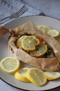 Lezzetli Morina Paketi: Fırında pişirilmiş morina balığı Parşömen kağıdına sarılıp mevsimlik sebzeler ve Citrus Enfüzyonu ile paketlendi