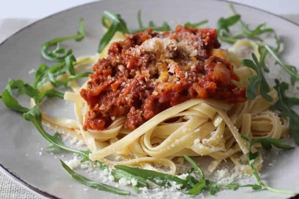 Tıraşlı Parmesan ve Taze Arugula ile geleneksel Bolonez Linguine