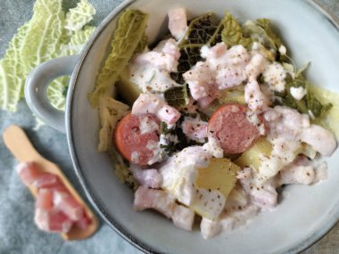 Steamed Savoy Cabbage with Potatoes, Sliced Smoked Sausage and a Creamy Bacon Sauce clipart