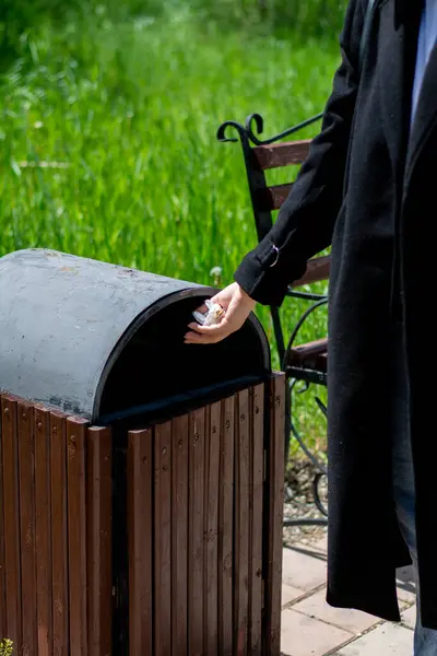 Parkta çantalı siyah takım elbiseli bir adam.