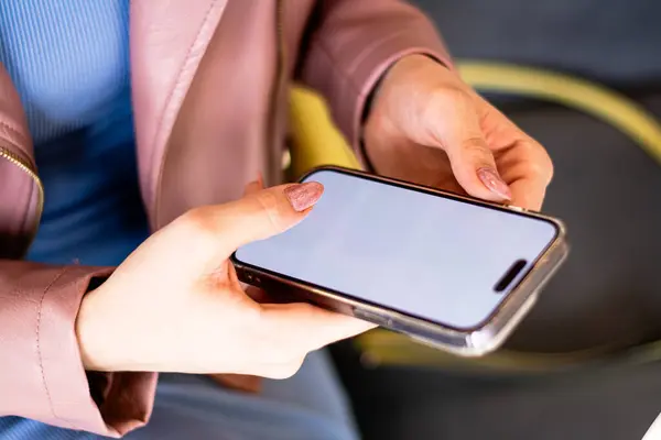 Elinde akıllı telefon kullanan bir kadın..